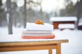 sauna accessories, like a towel, on snow-covered wood