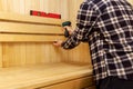 Sauna construction - man screwing wooden bench backrest Royalty Free Stock Photo