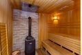 The sauna is lined with wood. Sweating room. Stove. Heater with stones for steam. Shelves for sitting and steaming. Royalty Free Stock Photo