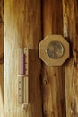 Sauna thermometer and hygrometer, hourglass on wooden wall.