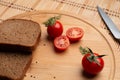 Tomates with black bread for lunch, Black bread with tomato on the wooden background Royalty Free Stock Photo