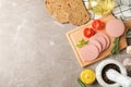 Sausage, bread, spices, towel and board on grey background