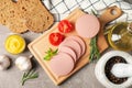 Sausage, bread, spices, towel and board on grey background Royalty Free Stock Photo