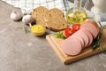 Sausage, bread, spices, towel and board on background, space for text Royalty Free Stock Photo