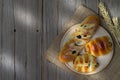 Sausage bread and wheat ears and sack on wooden background with morning sunlight ,top view