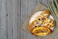 Sausage bread and wheat ears and sack on wooden background,top view