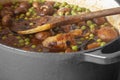 Sausage casserole in a casserole dish, with potato, mushrooms, tomatoes, peas and onion, in a beef stock Royalty Free Stock Photo