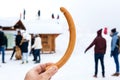 Sausage in hand with silhouettes of people in background