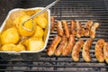 Sausage, hot dogs and potatoes on grill Royalty Free Stock Photo