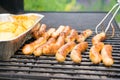 Sausage, hot dogs and potatoes on grill Royalty Free Stock Photo