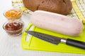 Sausage, knife on cutting board, bread, ketchup and squash caviar