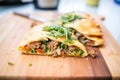 sausage and pepper filling in a calzone, half-sliced