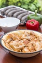 Seasoned raw chicken meat in a bowl stands on a table.