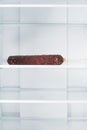 Sausage on a shelf in an empty refrigerator