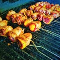 Sausage stuffed baby bell peppers wrapped in bacon and grilled in a smoker with apple-wood smoke