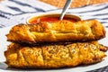 Sausages baked in dough sprinkled with salt and poppy seeds and bowl with tomatoes sauce in a rustic composition. Sausages rolls, Royalty Free Stock Photo