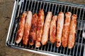 Sausages baked on a gas grill grate close-up top view. BBQ, picnic, barbecue food Royalty Free Stock Photo