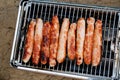 Sausages baked on a gas grill grate close-up top view. BBQ, picnic, barbecue food Royalty Free Stock Photo