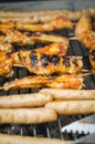 Sausages and chicken wings on smoking grill barbeque Royalty Free Stock Photo