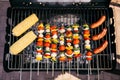 Sausages cooked outdoors on grill with corn and vegetables Royalty Free Stock Photo