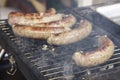 Sausages cooking over the hot coals on a barbecue fire Royalty Free Stock Photo