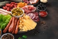 Sausages of different types, smoked meat, cheese and olives on a brown background with space to copy Royalty Free Stock Photo