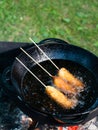 Sausages in dough on a stick are deep-fried Royalty Free Stock Photo