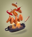 Sausages falling on the grill pan on a gradient isolated background