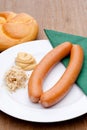 Vienna sausages with a roll, mustard and horseradish on a plate Royalty Free Stock Photo