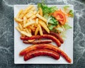 sausages, french potato fries and salad on plate Royalty Free Stock Photo