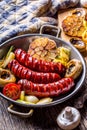 Sausages. Grill sausages. Grilled sausage with mushrooms garlic tomatoes and onions Royalty Free Stock Photo