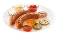 Sausages grilled with vegetables and sauce on the plate. Isolate