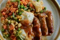 Sausages and onion gravy with vegetables Royalty Free Stock Photo