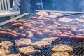 Sausages and pork steaks on the large barbeque Royalty Free Stock Photo