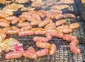 Sausages and pork steaks on the large barbeque Royalty Free Stock Photo