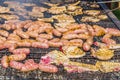 Sausages and pork steaks on the large barbeque Royalty Free Stock Photo