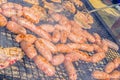 Sausages and pork steaks on the large barbeque Royalty Free Stock Photo