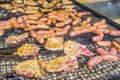 Sausages and pork steaks on the large barbeque Royalty Free Stock Photo