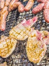 Sausages and pork steaks on the large barbeque Royalty Free Stock Photo