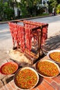 Sausages and Red Laos chili peppers on the bamboo baskets for natural drying on the sidewalk of Luang Prabang, Laos