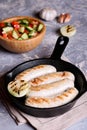 Sausages in rustic pan with onion. Frying pan with fried sausage