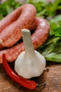 sausages in rustic style.Raw sausage rings, fresh parsley, red chili peppers on lettuce leaves on a wooden board Royalty Free Stock Photo