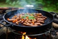 sausages sizzling on a portable camping hibachi