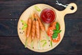 Sausages on skewers with ketchup and fresh tomatoes, served on a round wooden tray Royalty Free Stock Photo