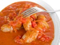 Sausages in tomato sauce with fork. Royalty Free Stock Photo