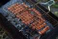 Sausages were fried on a metal grid over a fire. dinner in nature