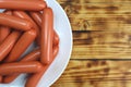 Sausages on a white plate stacked in a pile Royalty Free Stock Photo