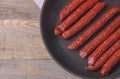 Sausages on a wooden kitchen board close up, cooking meat snacks Royalty Free Stock Photo