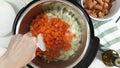 Saute chopped carrot and onion in a multi cooker. Cooking rice with meat and vegetables