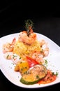 Saute shrimps, scallop, squid with pepper chilli with Mediterranian roast vegetable and saffron rice on white plate dark